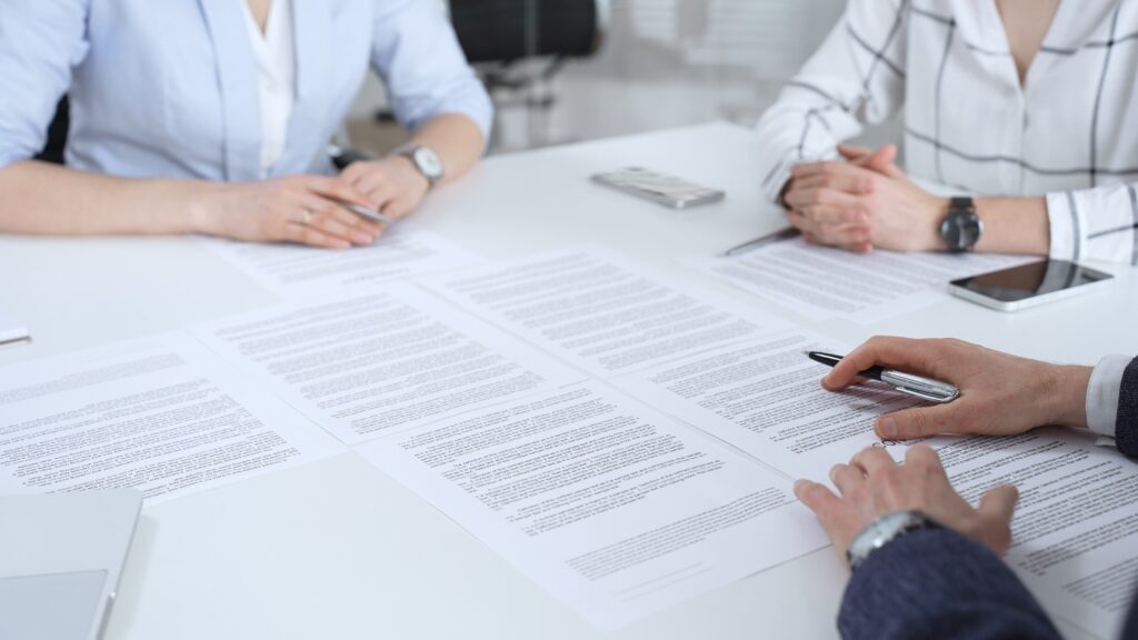 Court staff reviewing legal documents in an administrative office setting.