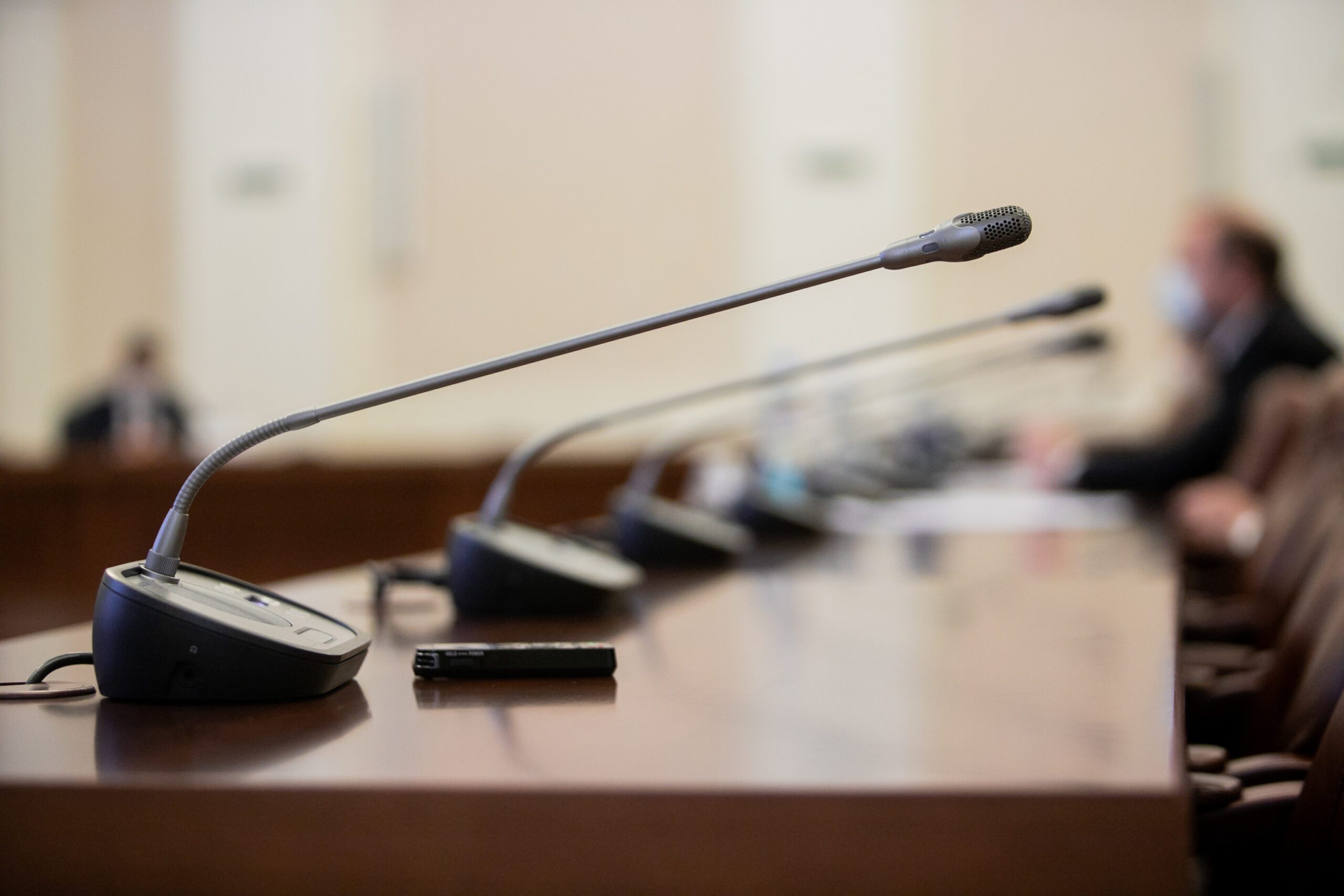 Professional microphones and a wireless presentation remote on a courtroom desk.