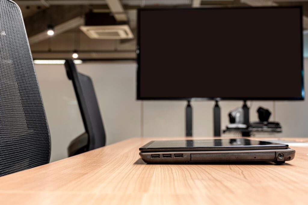 Laptop and high-definition display on a courtroom desk.