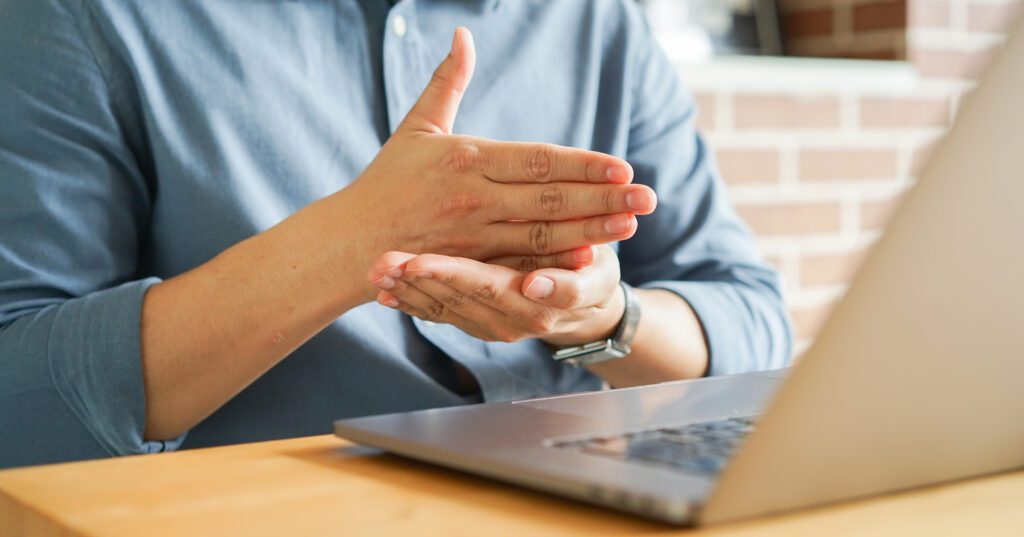 Person communicating using sign language during a video call.