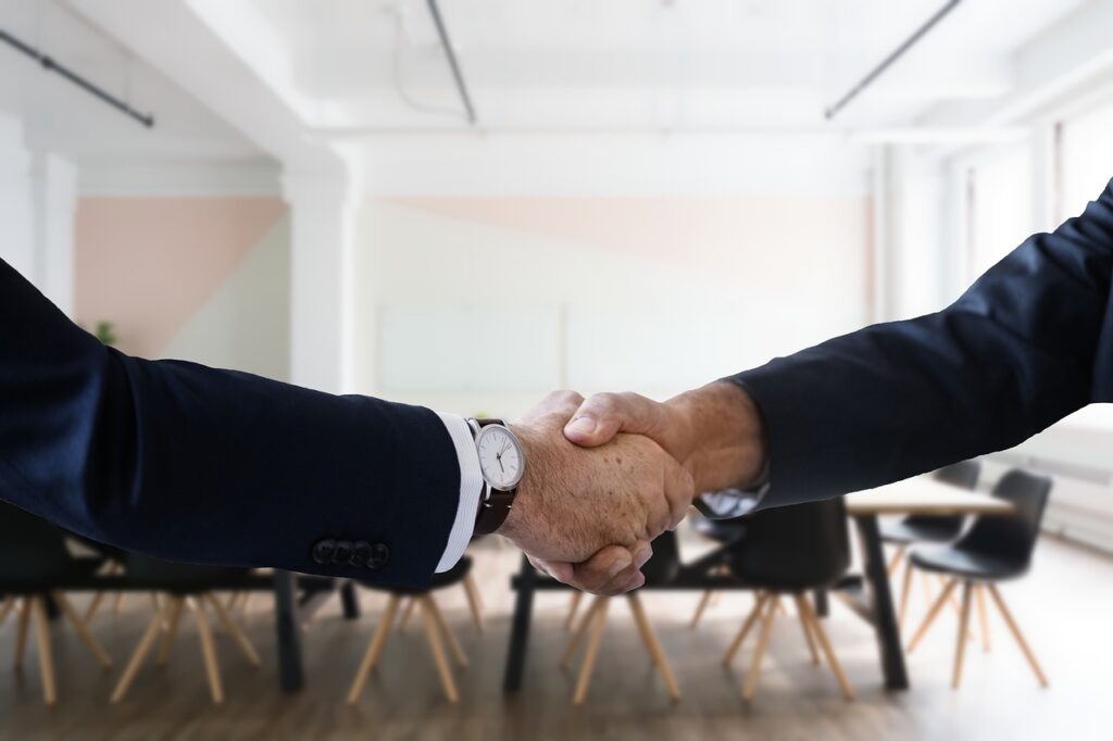 Two people shaking hands during a job interview.