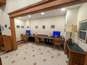 A dedicated computer workstation nook inside the library equipped with dual monitors for public legal research.